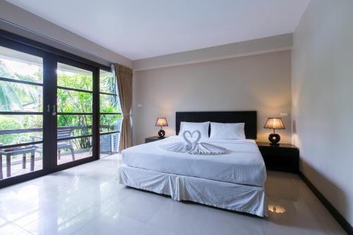 a bedroom with a bed and a large window at Thongtakian Resort in Lamai