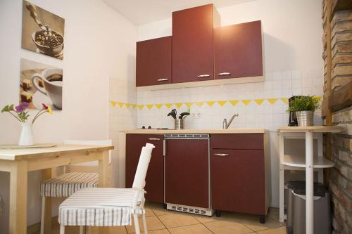 a kitchen with brown cabinets and a sink and a table at Ferienwohnungen und Ferienhäuser Gohr in Stralsund