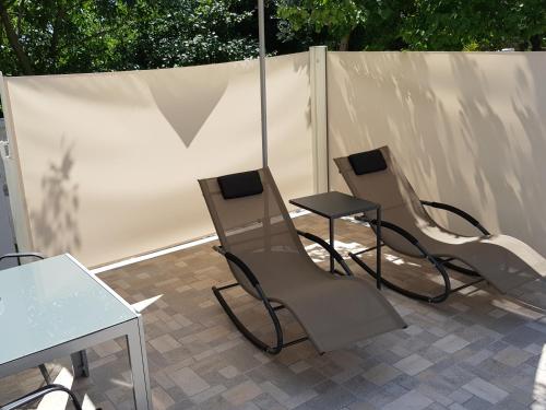 three chairs and a table and an umbrella on a patio at eVita Fazana Premium Studio Apartments in Fažana