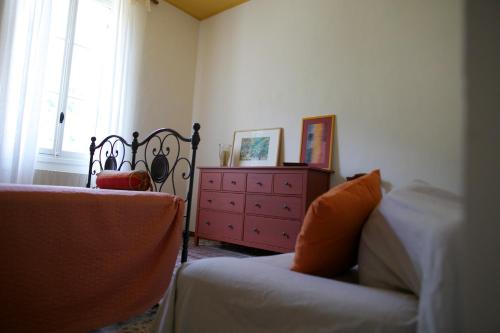 a bedroom with a bed and a dresser and a window at Le Gemme di Pigna in Pigna
