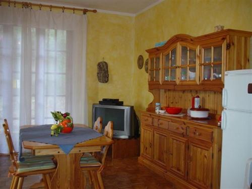 a kitchen with a table and a microwave and a refrigerator at Villetta a 300mt dal mare Cala Sinzias in Cala Sinzias