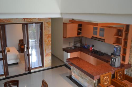a kitchen with wooden cabinets and a counter top at Villa Shanti Bali in Sempidi