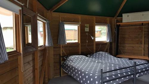 a bedroom with a bed in a wooden cabin at Camping Parc de la Brenne in Lignac