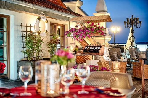 a table with glasses and flowers on a patio at Hotel Król Kazimierz in Kazimierz Dolny