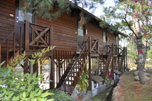 una casa de madera con escaleras en el lateral en 大湖底木屋民宿 en Gukeng