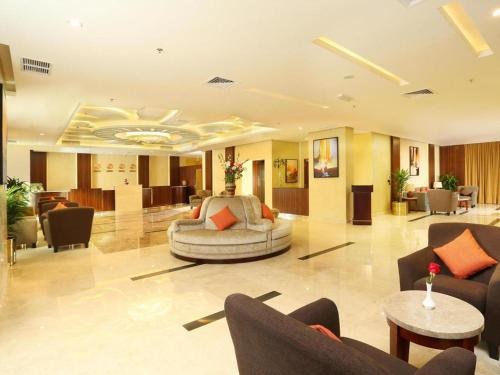 a lobby with a couch and chairs in a building at Best Western Plus Salmiya in Kuwait