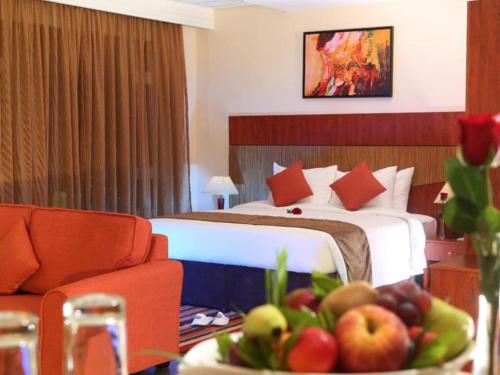a hotel room with a bed and a bowl of fruit at Best Western Plus Salmiya in Kuwait