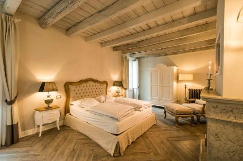 a bedroom with a large bed and a chair at La Vite 2.0 apartments in Desenzano del Garda