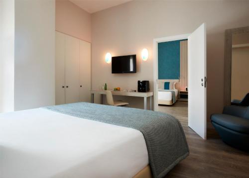 a hotel room with a bed and a television at Hotel Faro & Beach Club in Faro