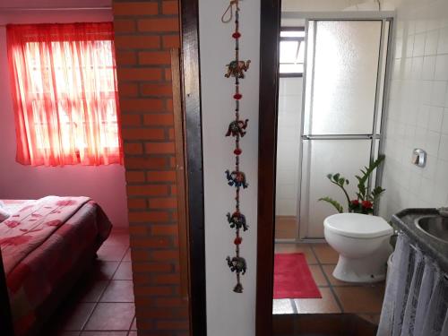 La salle de bains est pourvue d'un lit et de toilettes. dans l'établissement Casa Pousada Rosa dos Ventos, à Florianópolis