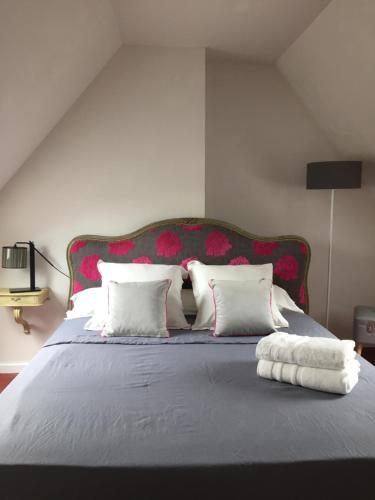 サン・テニャンにあるAu Carroir de Franceの大型ベッド(赤いヘッドボード、白い枕付)