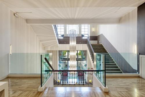 a staircase with a glass railing in a building at Italiana Hotels Milan Rho Fair in Rho