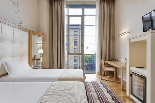 a hotel room with a bed and a desk at Italiana Hotels Milan Rho Fair in Rho