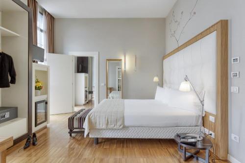 a bedroom with a large white bed and a table at Italiana Hotels Milan Rho Fair in Rho