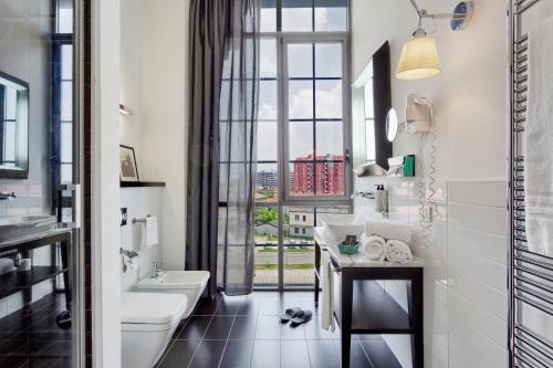 a bathroom with a sink and a toilet and a window at Italiana Hotels Milan Rho Fair in Rho