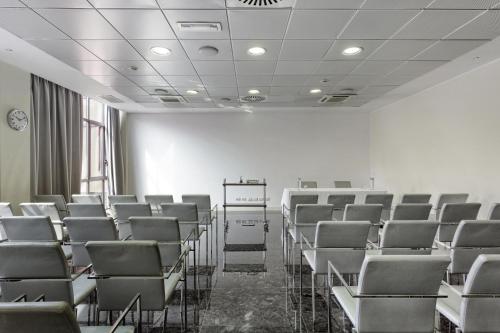 an empty room with chairs and a podium in it at Italiana Hotels Milan Rho Fair in Rho