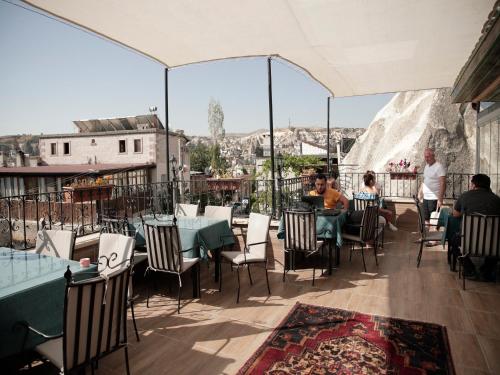 a restaurant with tables and chairs on a balcony at Milat Cave Hotel in Goreme