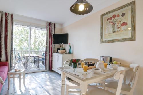 ein Wohnzimmer mit Tisch und Stühlen und eine Küche in der Unterkunft Village Pierre & Vacances Le Rouret in Grospierres