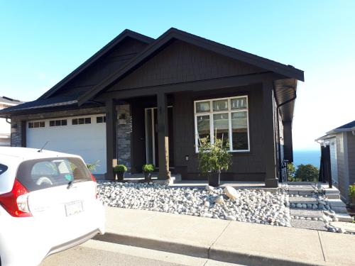 een huis met een auto ervoor geparkeerd bij 风语海景 in Nanaimo