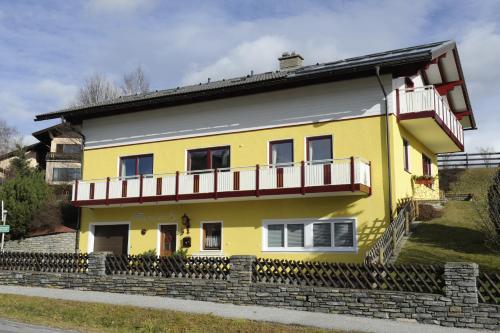 a yellow house with a balcony on top of it at Haus Sonnenschein Mariapfarr in Mariapfarr