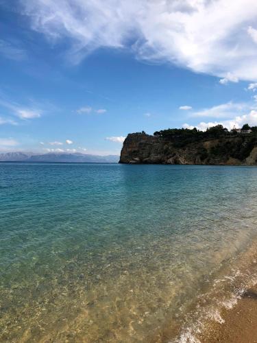 a beach with clear water and a rocky coastline at Scopello Guidaloca Villas in Scopello