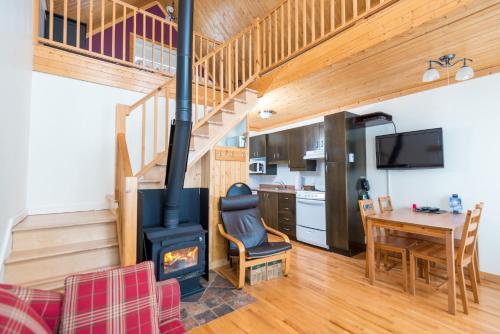 a living room with a wood stove and a table at Chalets Valmont in Cap-Chat