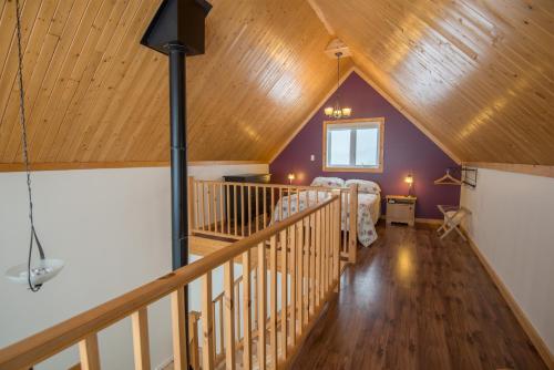 Zimmer im Dachgeschoss mit einem Bett und einer Holzdecke in der Unterkunft Chalets Valmont in Cap-Chat