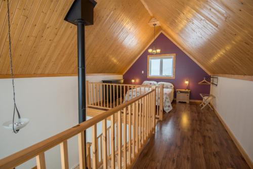a attic room with a bed and a wooden ceiling at Chalets Valmont in Cap-Chat