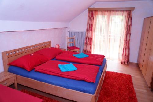 フェルデン・アム・ヴェルターゼーにあるGästehaus Reseiのベッドルーム1室(大型ベッド1台、赤と青の枕付)