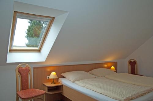 Schlafzimmer mit einem Bett, einem Fenster und einem Stuhl in der Unterkunft Sonnenhus - Rügen in Ostseebad Sellin
