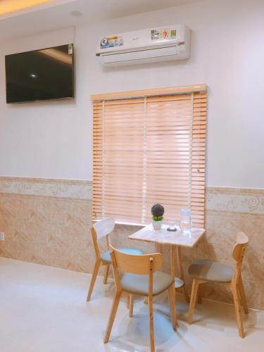 a table and chairs in a room with a window at Tomorrow Hostel Vũng Tàu - Tomorrow Homestay in Vung Tau
