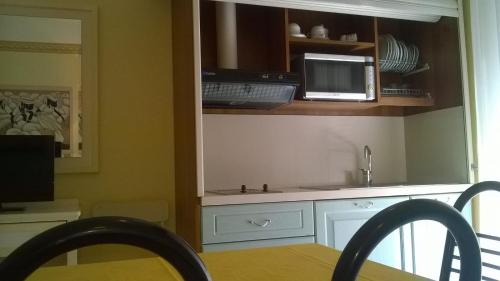 a kitchen with a sink and a microwave at Residence Record in Rimini