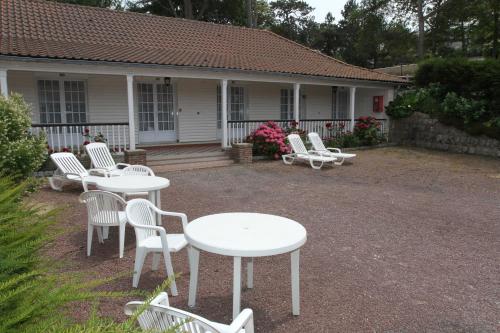 a group of tables and chairs in front of a house at Hotel Royal Albion in Mesnil-Val-Plage