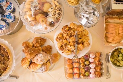 a table full of different types of bread and pastries at Hotel Maison Tresnuraghes in Tresnuraghes