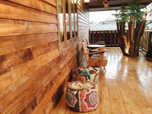 a room with a wooden wall and two chairs at Petit Paramata in Phitsanulok