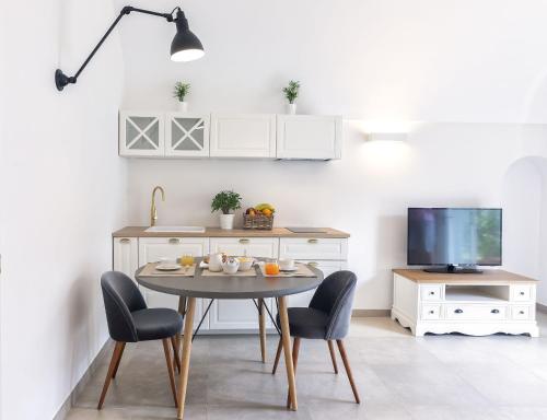 una cucina con tavolo, sedie e TV di B&B Marina Garden a Ischia