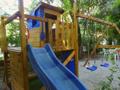a playground with a blue slide and a house at Hotel Annita Cervia in Cervia