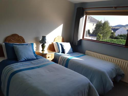two beds in a room with a window at Shalom in Carlingford