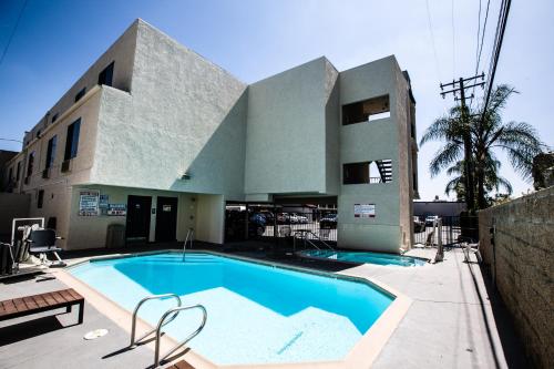 a building with a swimming pool in front of a building at Anaheim Carriage Inn in Anaheim