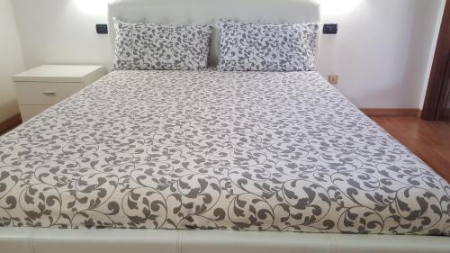 ein Bett mit einer schwarzen und weißen Bettdecke und Kissen in der Unterkunft Apartment Regina Uno in Como