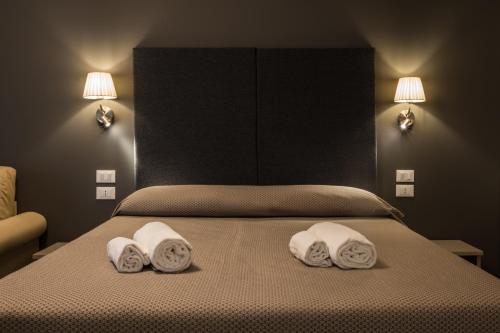 a bedroom with a bed with two pillows on it at Garda Guest House in Colà di Lazise