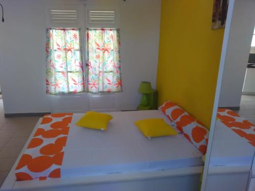 Zimmer mit einem Bett mit zwei Kissen darauf in der Unterkunft Les Colibris in Sainte-Anne