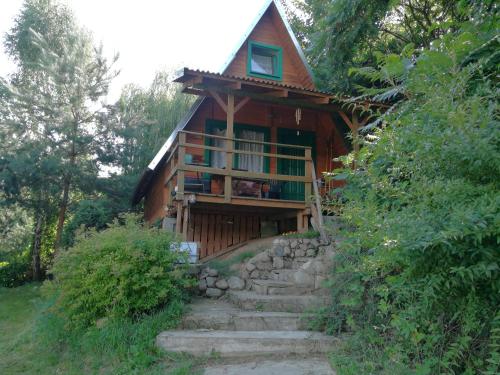 ein Haus mit Treppen, die zu ihm führen in der Unterkunft Domek nad jeziorem in Wielki Głęboczek