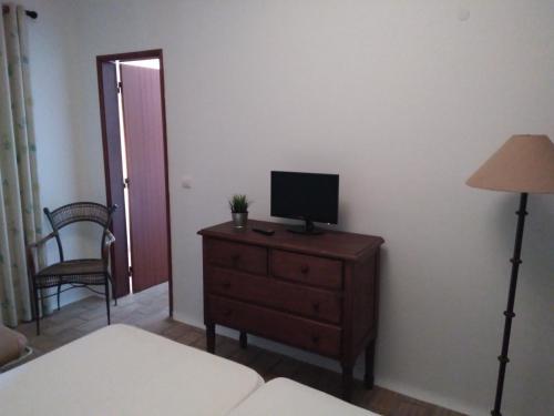- une chambre avec une télévision sur une commode avec une lampe dans l'établissement Casa Fatana, à São João dos Caldeireiros