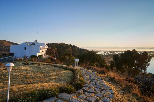 a stone path leading to a white building on a hill at GHL Hotel Lago Titicaca in Puno