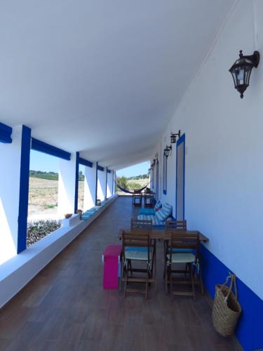 Cette chambre est dotée de tables et de chaises en bois ainsi que de murs bleus. dans l'établissement Vale do Boto-Quinta com 3 casas, à Castro Marim