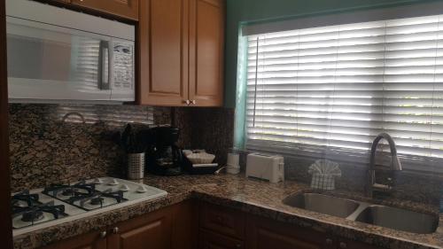 uma cozinha com um lavatório, um fogão e uma janela em Courtney's Place Historic Cottages & Inns em Key West