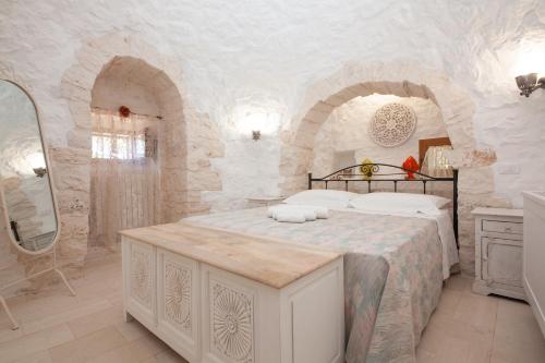a bedroom with a bed in a stone room at Trullo Siamese in Alberobello