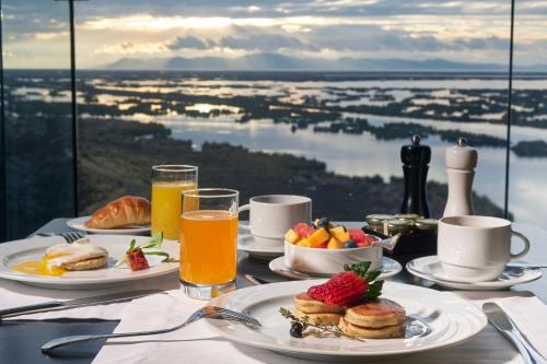 a table topped with plates of breakfast food and juice at GHL Hotel Lago Titicaca in Puno