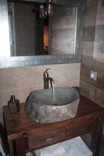 a bathroom sink on a wooden table with a mirror at Apartamentos Numancia in Garray